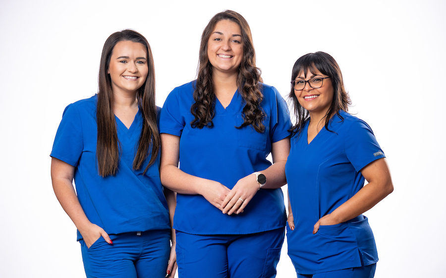 Three nurses in blue scrubs