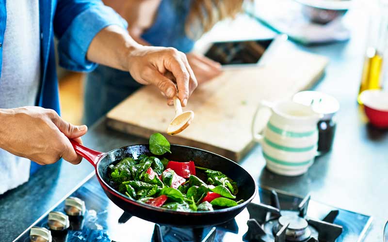 A man cooking vegetables in a pan