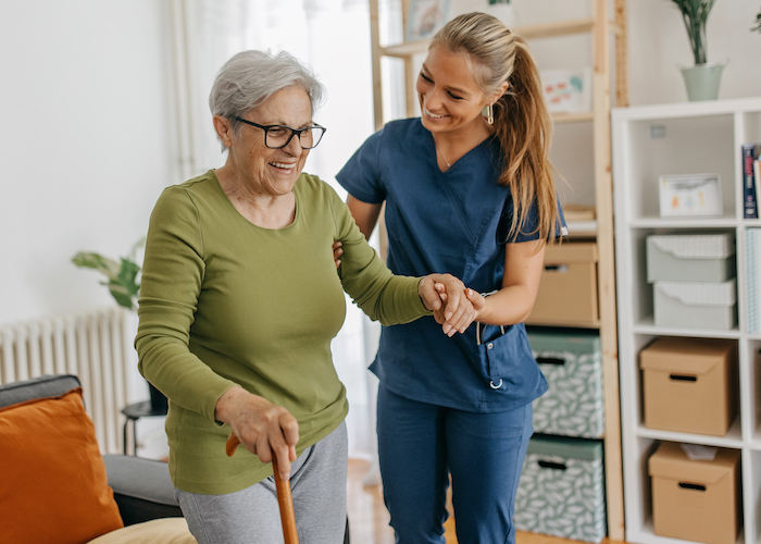 A nurse helping an elderly woman walk