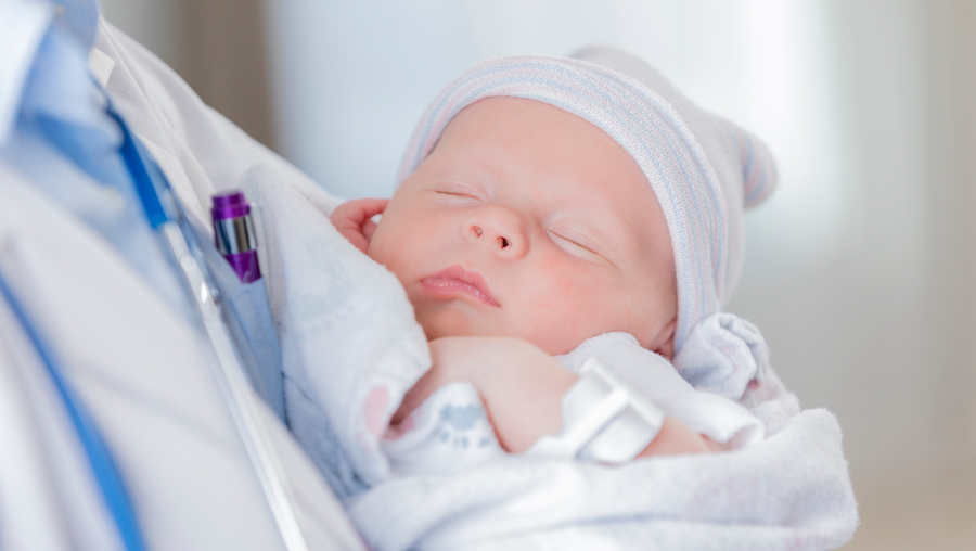 A doctor holding a newborn baby